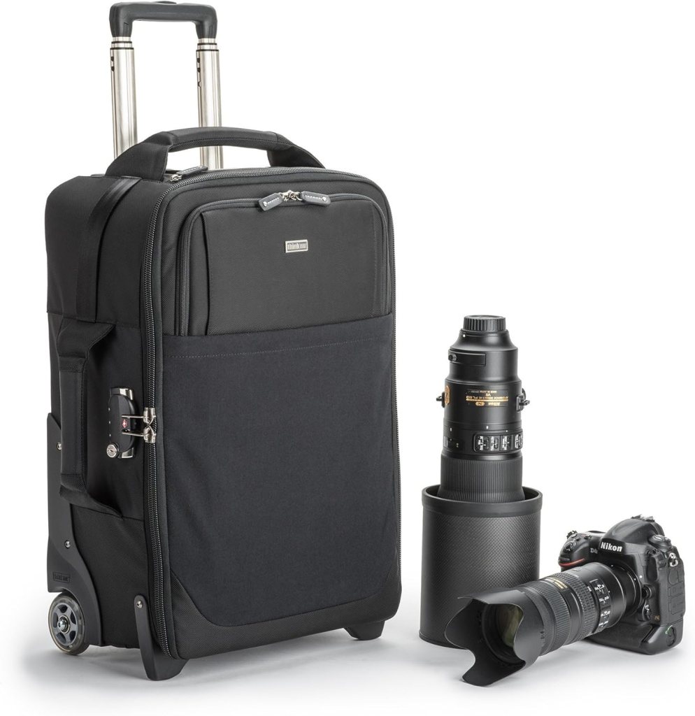 Rolling camera bag with extendable handle, beside a DSLR camera and telephoto lens.