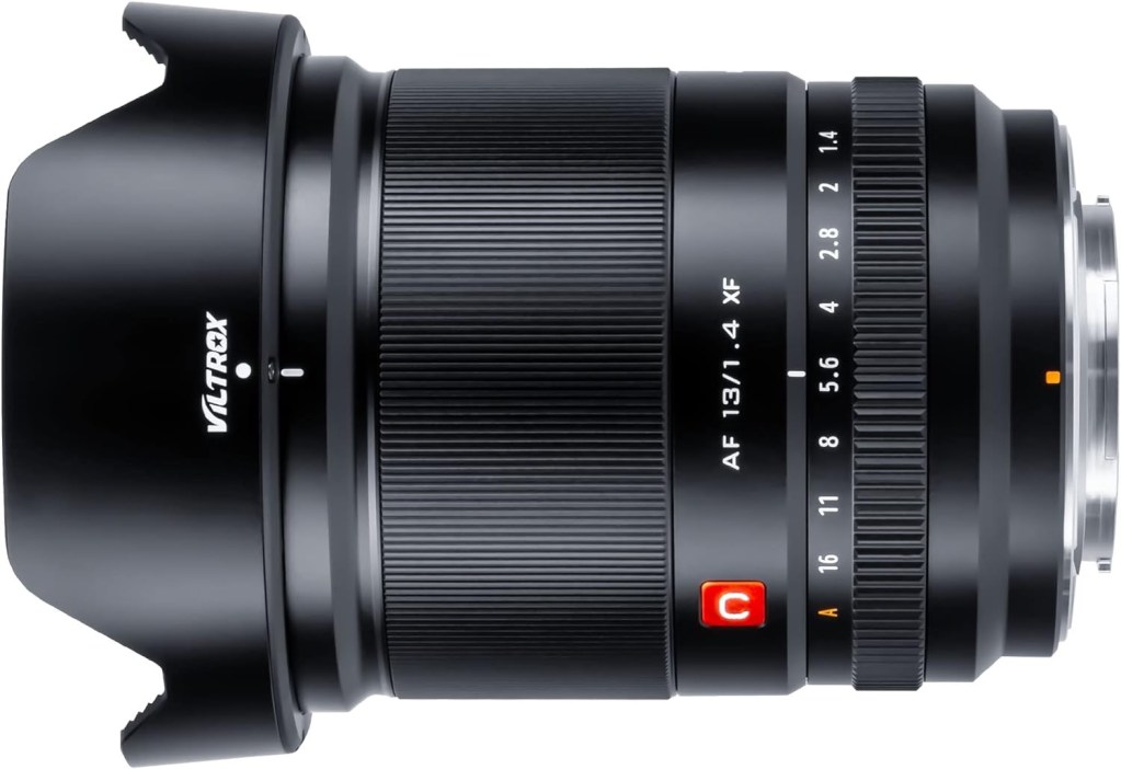 Close-up image of the Viltrox 13mm f/1.4 AF lens, showcasing its sleek black design, focus and aperture rings, and lens hood.