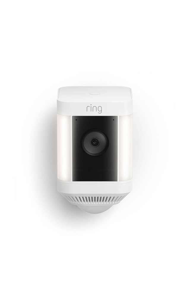 A Ring security camera with built-in lights, featuring a black lens in the centre and a sleek white exterior.