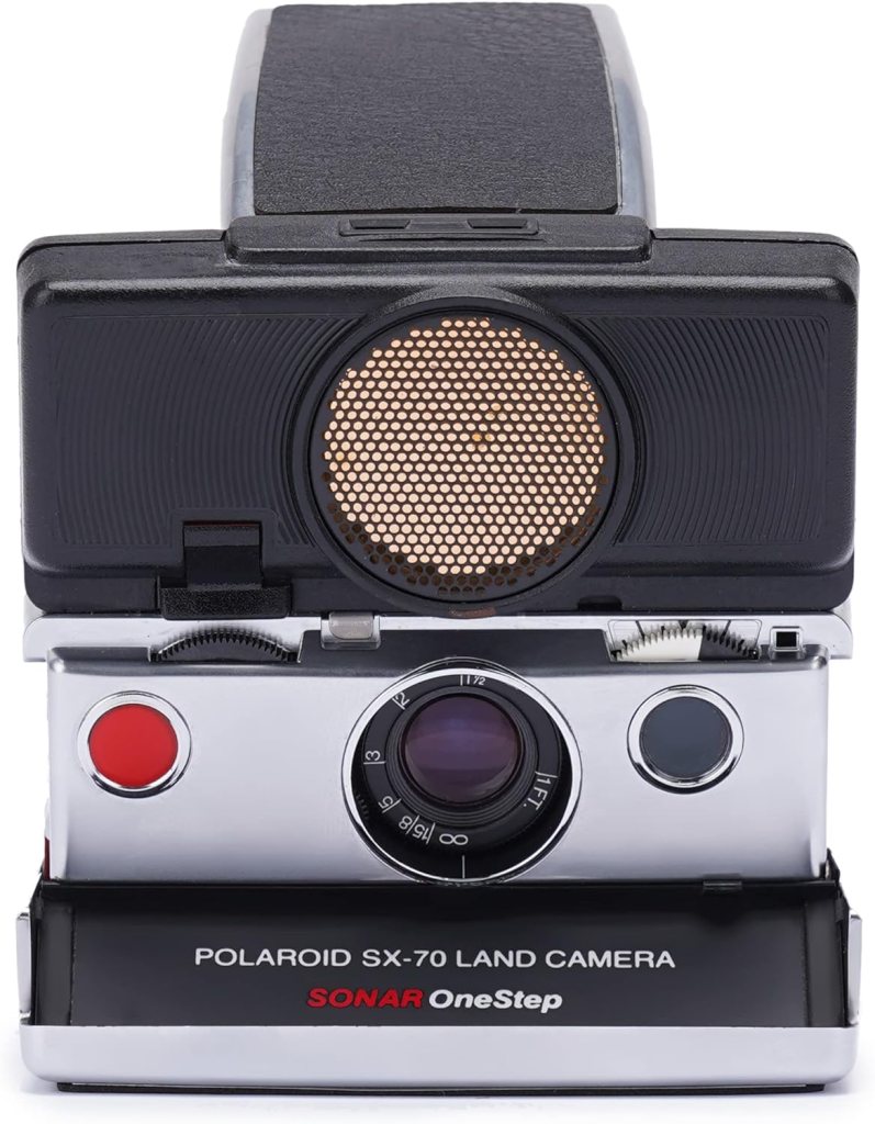 Front view of a Polaroid SX-70 Land Camera, featuring a prominent lens, a red shutter button, and a distinctive model name displayed on the front.